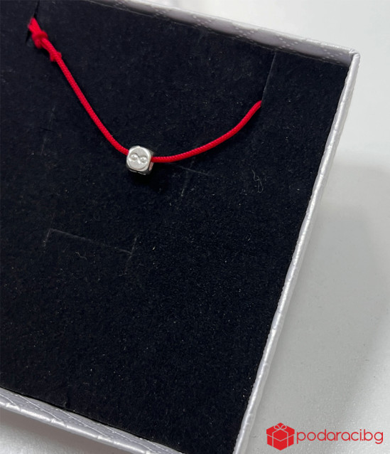 Гривна с червен конец и кубче със символ за безкрайност